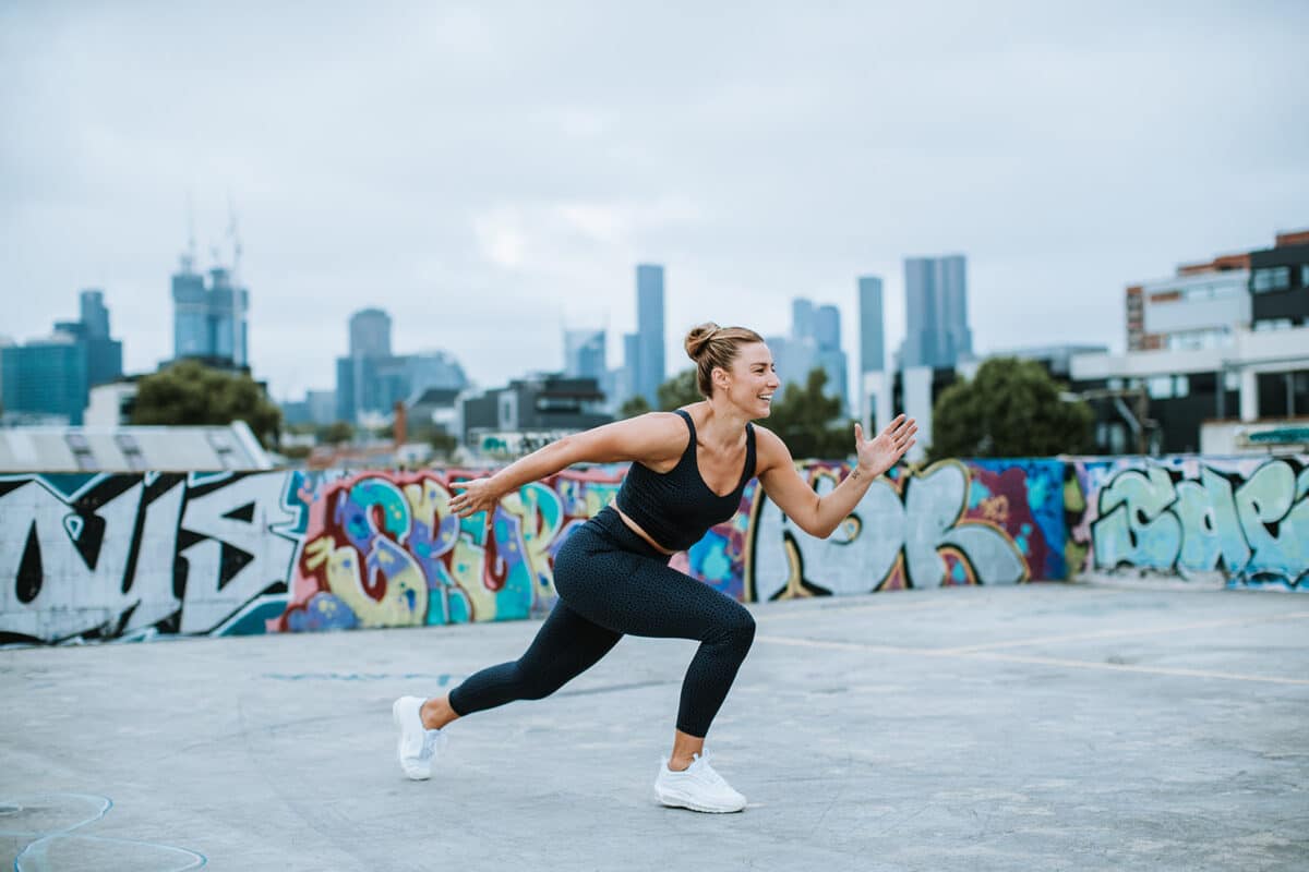 Madi Browne moves athletically in front of a city scape of Melbourne with Upstate Studios