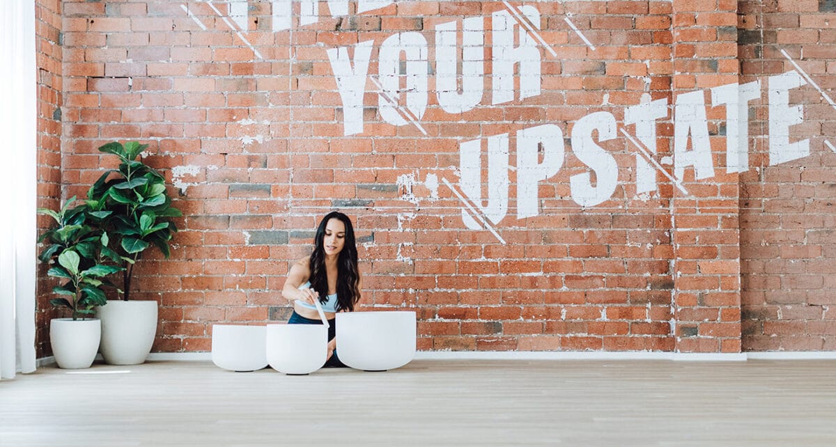 Upstate Yoga teacher and fitness instructor plays crystal soundbowls in yin yoga class.