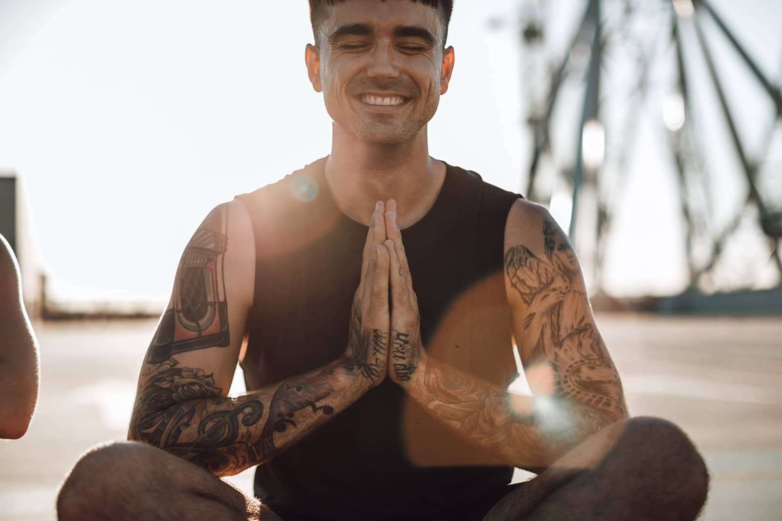 Man smiles brightly while sitting in a yoga posture at Upstate Studios.